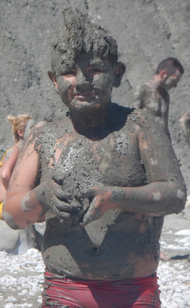 Young boy covered in mud
